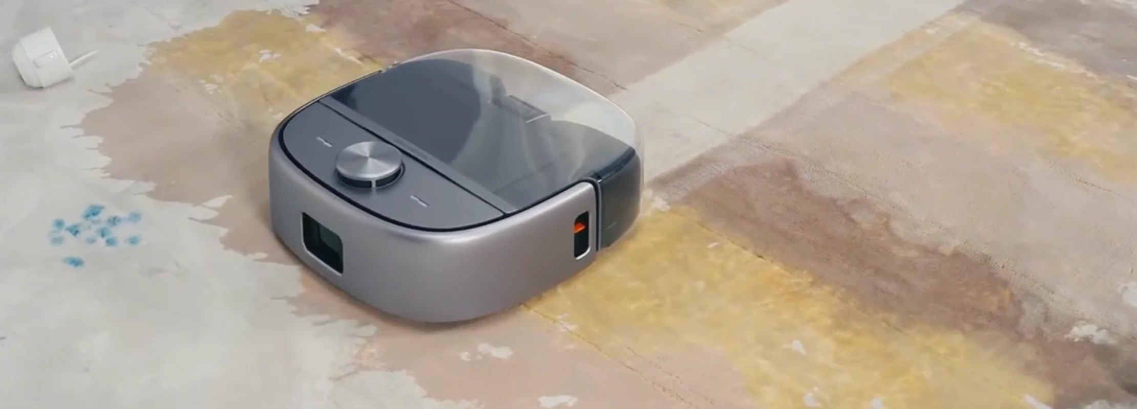 Robotin R2 robot vacuum and carper cleaner cleaning up a spilt beverage on a carpet leaving a visible clean path