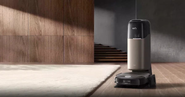 Frame from Eufy promotional video showing the Omni S2 and base station on a hard wood floor covered with a rug. A staricase shown in the background.