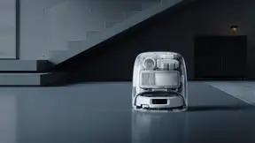 DJI ROMO robot vacuum and self-cleaning dock in a modern living room